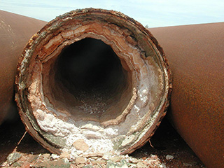 Cross-section of a pipe narrowed by heavy scale build-up
